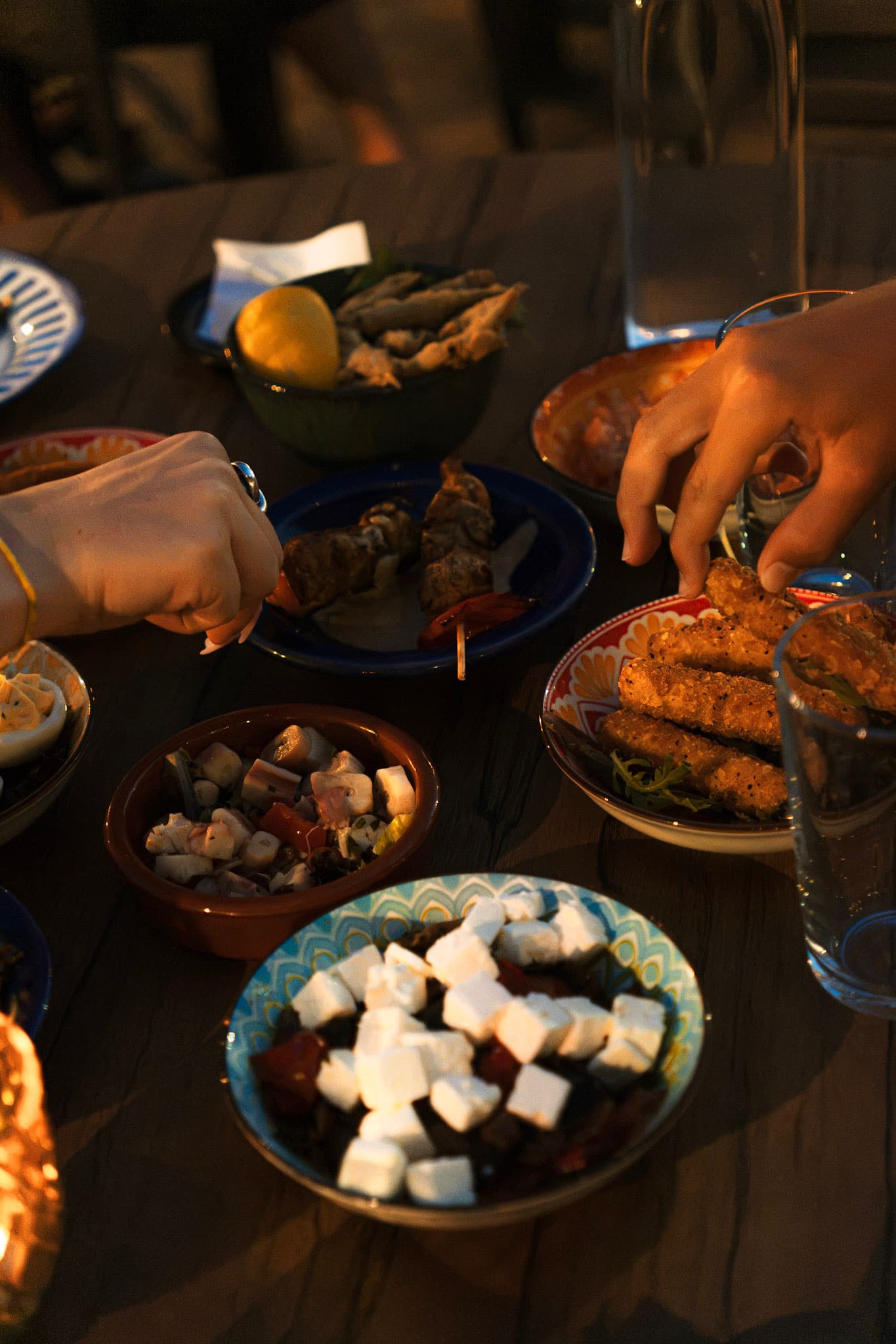 Des mains qui piochent dans les petites assiettes partagées